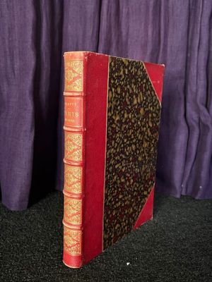 un vieux livre posé sur une table, à côté d'un rideau violet