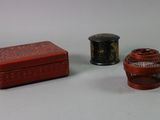 deux petites boîtes rouges et noires posées l'une à côté de l'autre sur une table