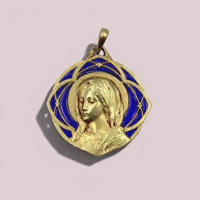 un gros plan sur un pendentif doré et bleu représentant le visage d'une femme