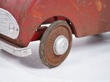 a red toy truck with wheels on a white surface