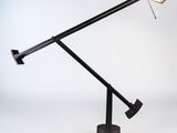 une image représentant une lampe de bureau avec un pied noir et une ampoule rouge