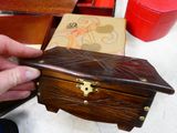 a person that is holding a wooden box on a table