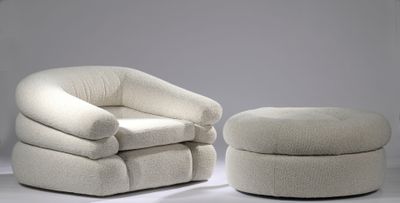 une chaise blanche et un pouf dans une pièce