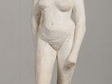 a white statue of a man standing on a wooden table