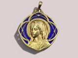 a close up of a gold and blue pendant with a woman ' s face