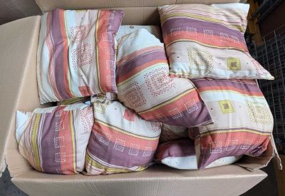 many pillows in a box on the floor