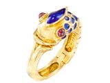 un gros plan d'une bague en or sertie de pierres bleues et rouges