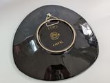 a black plate with a gold rim on a white table