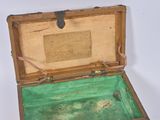 a small wooden box with a green lid on a white surface