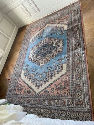 rug on the floor in a room with a bed and a window
