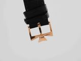 a close up of a black watch strap with a gold buckle