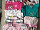 plusieurs pyjamas et t-shirts d'enfants disposés sur une boîte en carton