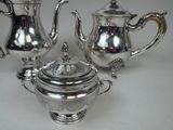 a silver tea set on a white table