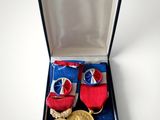 two medals and a pair of shoes in a box