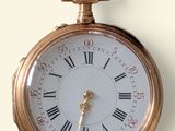 une montre de poche en or avec des chiffres romains sur le cadran