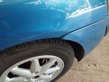 a close up of a blue car with a flat tire