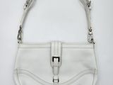 a white purse on a white surface with a metal handle