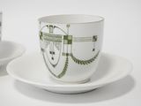 two cups and saucers with designs on them