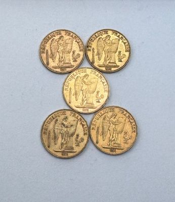 cinq types différents de pièces d'or sur un fond blanc