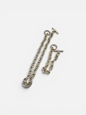 a close up of a pair of silver chains on a white surface