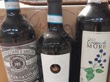 three bottles of wine sit in a cardboard box on a table