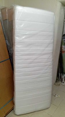 un matelas qui se trouve au milieu d'une pile de cartons