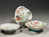 Plusieurs pièces de porcelaine chinoise sont posées sur une surface grise