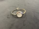 a close up of a watch on a table with a box in the background