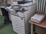un bureau avec une imprimante et une chaise dans une pièce
