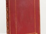 un livre en cuir rouge avec des finitions dorées et une bordure dorée