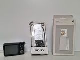 un appareil photo Sony à côté d'un téléphone Sony dans une boîte