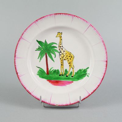 une assiette sur laquelle sont représentés une girafe et un palmier
