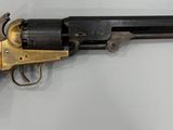 un gros plan d'un revolver accroché au mur, avec une crosse en bois