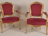 paire de chaises dorées avec des coussins rembourrés rouges et des bordures dorées