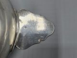 a silver pot with a lid sitting on a table