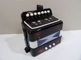 a black and white accordion sitting on a white table