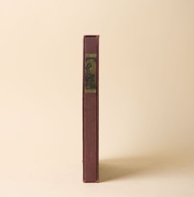 un vieux livre posé sur une table à côté d'un mur blanc