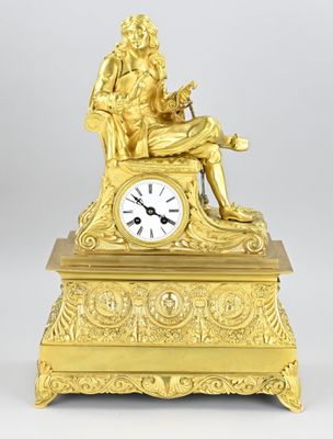 a gold clock that is sitting on a table