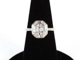 un gros plan d'une bague en diamant posée sur un présentoir noir