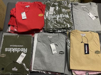 un grand nombre de t-shirts posés sur une table
