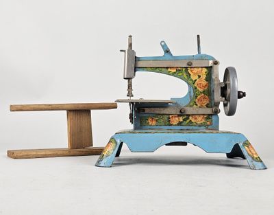 une petite machine à coudre posée à côté d'une table en bois