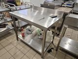 une table de travail en acier inoxydable sur laquelle se trouve un téléphone