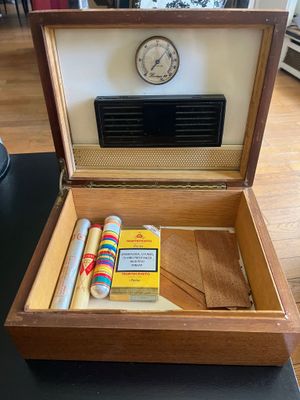a wooden box with a clock and a cigarette in it