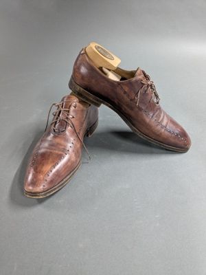 a pair of brown shoes sitting on top of a gray surface