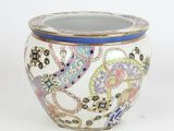 a white vase with a blue rim and a design on it