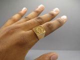 a person ' s hand with a gold ring on it