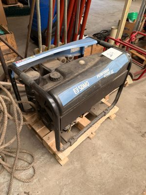 un petit compresseur d'air posé sur une palette dans un garage