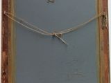 an old picture frame hanging on a wall with a rope
