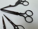 three pairs of scissors sitting on a table next to each other