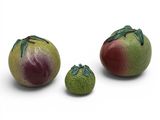 trois tomates et deux poires posées sur une surface blanche